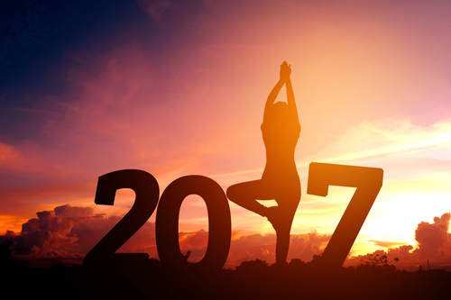 Silhouette young woman practicing yoga on 2017 new year